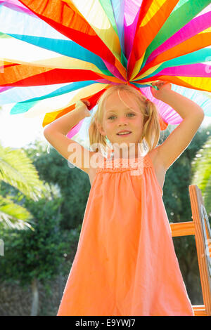 Girl putting up decoration in garden Stock Photo