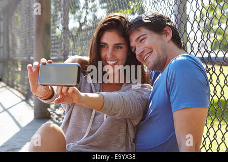 Young couple taking selfie by wire fence Stock Photo