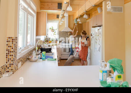 Young women cleaning kitchen with green cleaning products Stock Photo