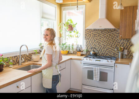 Young woman cleaning kitchen with green cleaning products Stock Photo