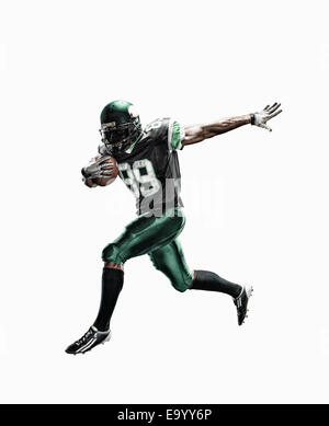 Studio shot of male football player running with ball Stock Photo