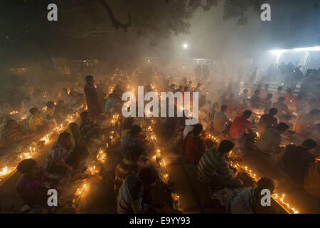 Narayangonj, Bangladesh. 4th Nov, 2014. People of Hindu Community (Bangladeshi) celebrating 'Rakher Upobas''a culture in every Bengali month Kartik. It's a fast day for keeping safe all of own family members from all kinds of black issues. Hindu Man and Women are celebrating this ritual festival by lighting lamps and candles from just sunset with some gift (fruits, sweets, coconut, cow milk etc.) for their belief 'Baba Loknath'' Hindus one of the God. And every fans keep themselves fasting until the lamps burn-out. Credit:  ZUMA Press, Inc./Alamy Live News Stock Photo