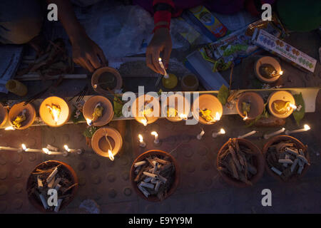 Narayangonj, Bangladesh. 4th Nov, 2014. People of Hindu Community (Bangladeshi) celebrating 'Rakher Upobas''a culture in every Bengali month Kartik. It's a fast day for keeping safe all of own family members from all kinds of black issues. Hindu Man and Women are celebrating this ritual festival by lighting lamps and candles from just sunset with some gift (fruits, sweets, coconut, cow milk etc.) for their belief 'Baba Loknath'' Hindus one of the God. And every fans keep themselves fasting until the lamps burn-out. Credit:  ZUMA Press, Inc./Alamy Live News Stock Photo