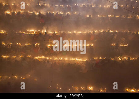 Narayangonj, Bangladesh. 4th Nov, 2014. People of Hindu Community (Bangladeshi) celebrating 'Rakher Upobas''a culture in every Bengali month Kartik. It's a fast day for keeping safe all of own family members from all kinds of black issues. Hindu Man and Women are celebrating this ritual festival by lighting lamps and candles from just sunset with some gift (fruits, sweets, coconut, cow milk etc.) for their belief 'Baba Loknath'' Hindus one of the God. And every fans keep themselves fasting until the lamps burn-out. Credit:  ZUMA Press, Inc./Alamy Live News Stock Photo