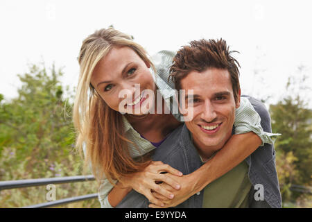 Couple playing piggyback ride in park Stock Photo - Alamy
