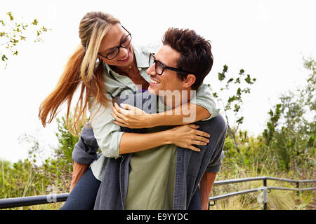 Couple playing piggyback ride in park Stock Photo - Alamy
