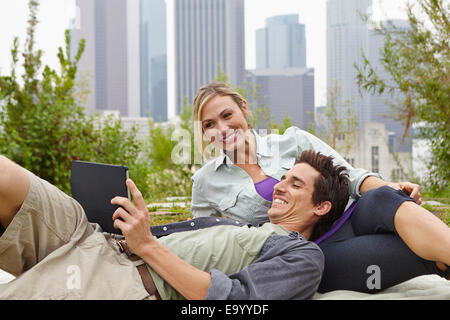 Couple relaxing in park by city Stock Photo