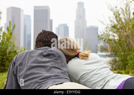 Couple relaxing in park by city Stock Photo