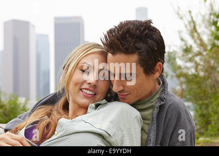 Couple relaxing in park by city Stock Photo