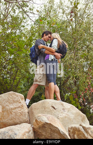 Couple hugging on rock Stock Photo