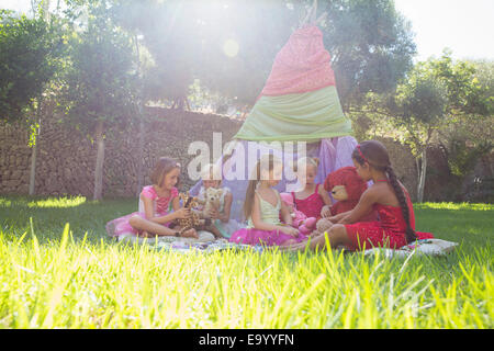 Five girls playing with teddy bears in front of teepee Stock Photo