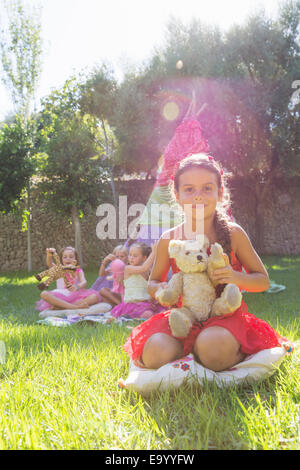 Portrait of girl holding teddy bear in front of teepee Stock Photo
