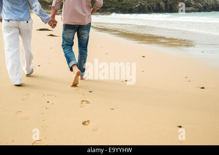 Cropped shot of mature couple holding hands whilst strolling on beach, Camaret-sur-mer, Brittany, France Stock Photo