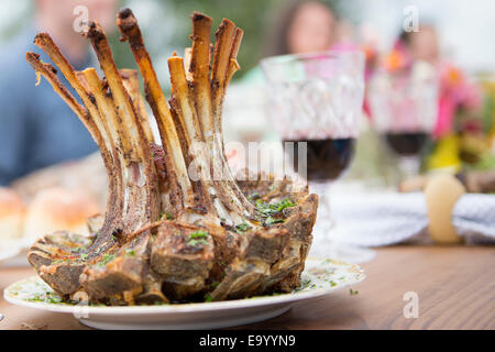Rack of lamb on plate at family meal, close-up Stock Photo