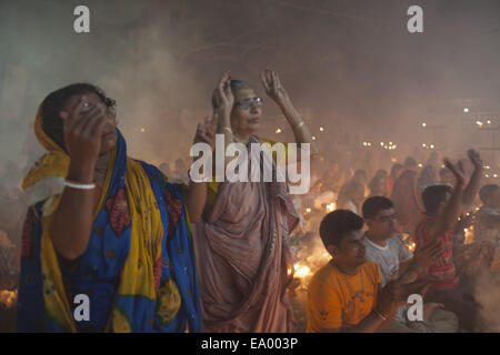 Narayangonj, Bangladesh. 4th Nov, 2014. People of Hindu Community (Bangladeshi) celebrating 'Rakher Upobas''a culture in every Bengali month Kartik. It's a fast day for keeping safe all of own family members from all kinds of black issues. Hindu Man and Women are celebrating this ritual festival by lighting lamps and candles from just sunset with some gift (fruits, sweets, coconut, cow milk etc.) for their belief 'Baba Loknath'' Hindus one of the God. And every fans keep themselves fasting until the lamps burn-out. Credit:  ZUMA Press, Inc./Alamy Live News Stock Photo