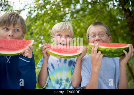Friends eating watermelon in garden Stock Photo