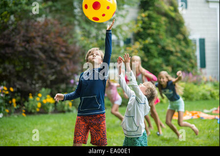 Children playing ball game in garden Stock Photo