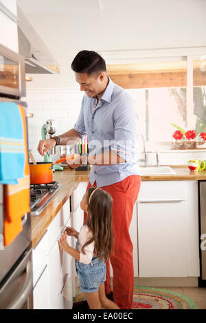 Father and daughter cooking in kitchen Stock Photo