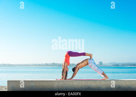 Young man and woman practicing yoga on Pacific beach, San Diego, California, USA Stock Photo