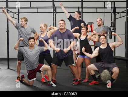 Portrait of eight people flexing muscles in gym Stock Photo