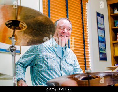 Mature man playing drums at home Stock Photo