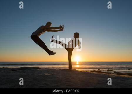 People in jumping and kicking poses on Windansea beach, La Jolla, California Stock Photo