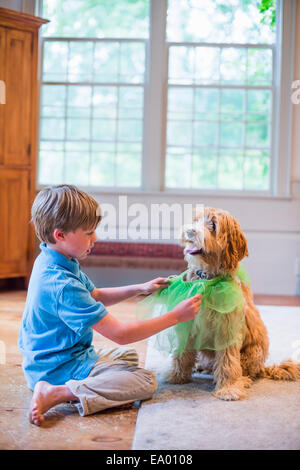 Young boy playing dress up with pet dog Stock Photo