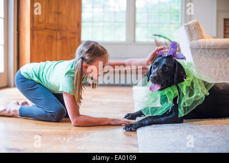 Young girl playing dress up with pet dog Stock Photo