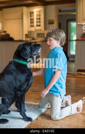 Young boy playing with pet dog Stock Photo