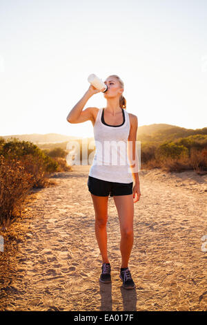 Female jogger drinking from water bottle, Poway, CA, USA Stock Photo