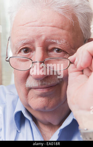 Senior man looking over glasses Stock Photo