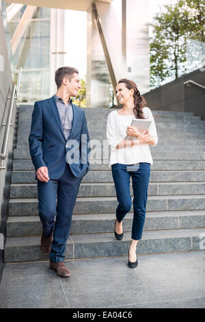 Rear view of young businessman and woman walking down stairway, London, UK Stock Photo