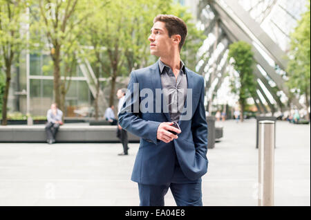 Worried looking young businessman at Broadgate Tower, London, UK Stock Photo