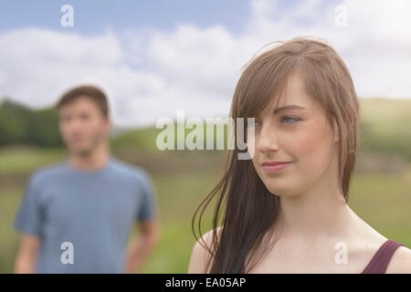 Young couple standing apart and looking away in rural landscape, close up Stock Photo