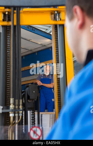 Factory worker operating forklift Stock Photo