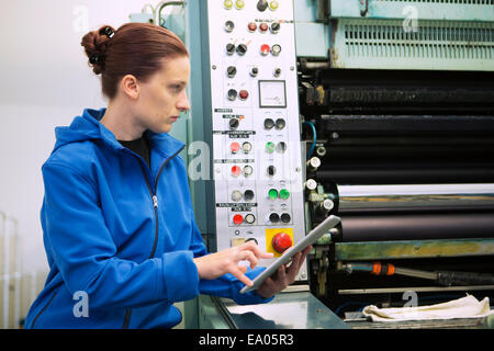 Factory worker at control panel of machinery Stock Photo