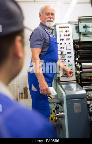 Factory worker at control panel of machinery Stock Photo