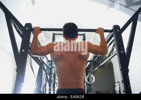Man doing pull ups in gym Stock Photo