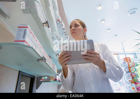Pharmacist in pharmacy holding digital tablet Stock Photo