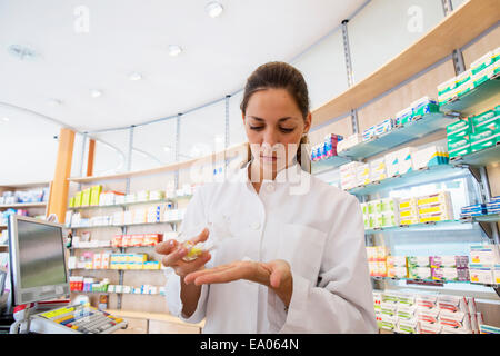 Pharmacist in pharmacy holding medicine in hand