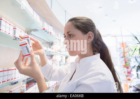 Pharmacist in pharmacy reading medicine box Stock Photo