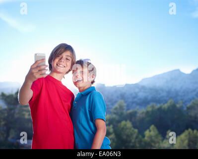 Two brothers taking selfie on smartphone, Majorca, Spain Stock Photo