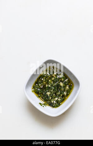 Pesto sauce  in a dipping bowl on simple white background Stock Photo