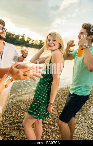 Group of friends dancing on beach Stock Photo