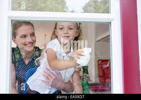 Mother and daughter cleaning window Stock Photo