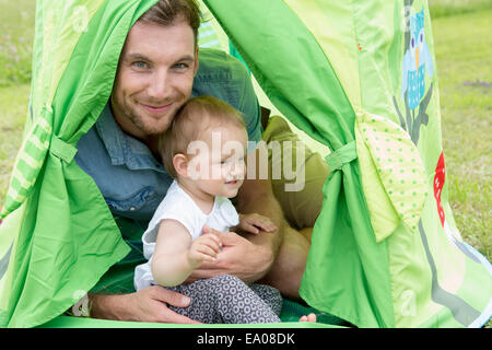 Father with baby daughter in tent Stock Photo