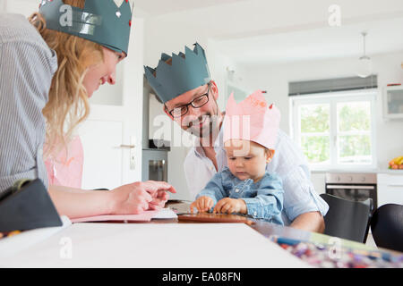 Parents with baby daughter wearing homemade crowns Stock Photo