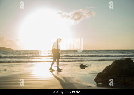 Mature man, walking on beach, along coastline Stock Photo