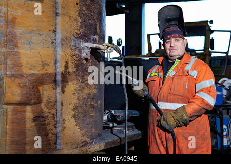 Portrait of mature welder in quarry workshop Stock Photo