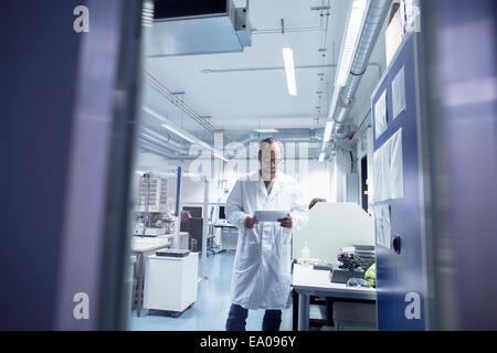 Lab assistant checking details on digital tablet Stock Photo
